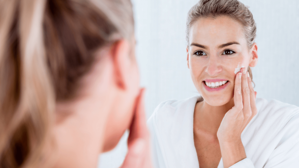 Mujer hidratándose la piel poniéndose crema en la cara
